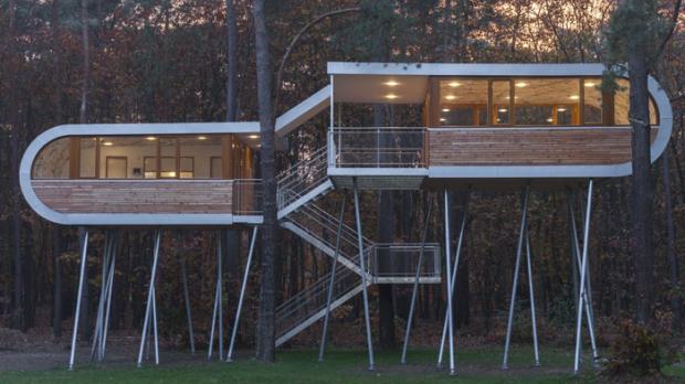 ′The Treehouse′, ein futuristisch anmutendes Baumhaus aus Holz und Glas, durchgängig illuminiert mit Nimbus LED-Leuchten. (Foto: baumraum)